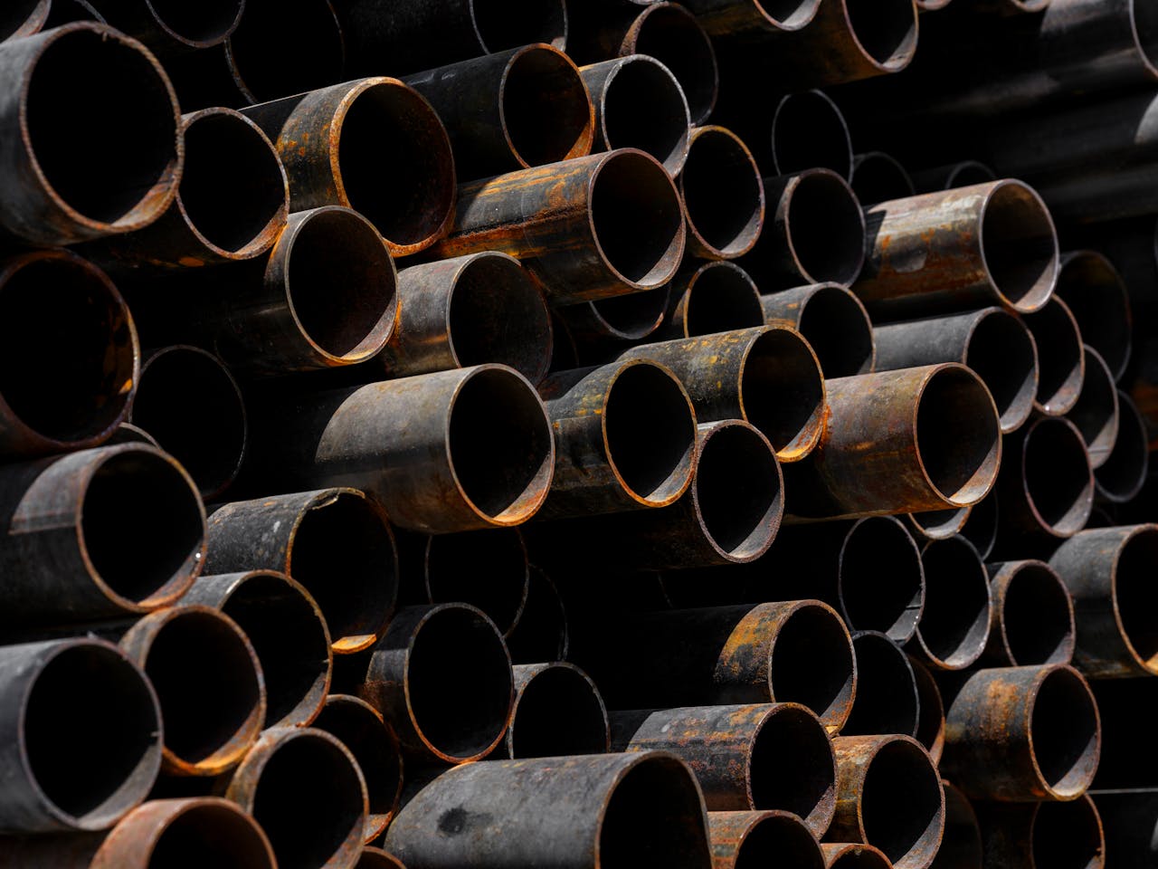 Close-up of stacked rusty pipes showcasing industrial recycling processes.